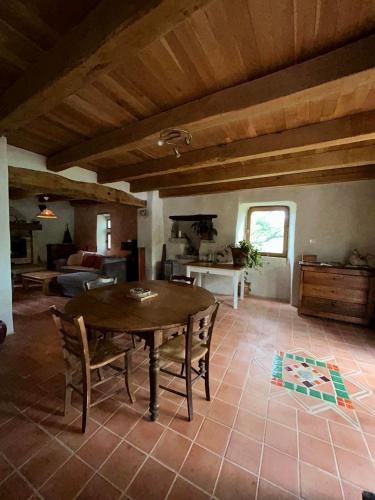 un salon avec une table et des chaises en bois dans l'établissement Le Mas du Savel, à Gagnières