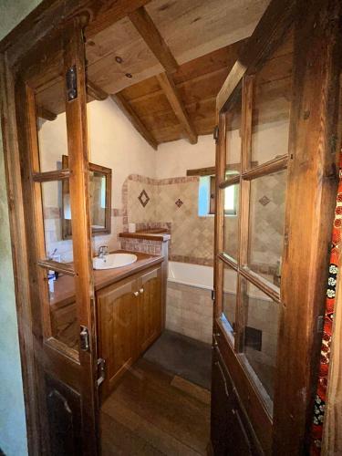 une salle de bain avec un lavabo et une baignoire dans l'établissement Le Mas du Savel, à Gagnières