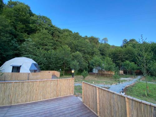 a yurt on a wooden deck with a fence at Evaland Glamping in Ardeşen