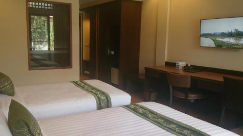 a hotel room with two beds and a desk at Phurua Sanctuary Resort and Spa in Phu Rua