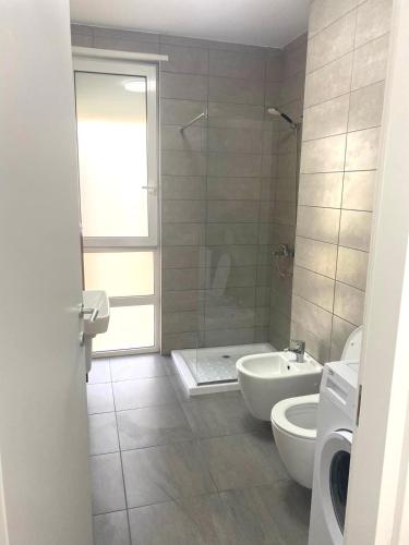 a bathroom with a tub and a toilet and a sink at San Pietro Dream Apartment in Lalzit Bay