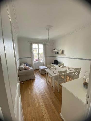 une cuisine et un salon avec une table et des chaises dans l'établissement Appartement Saint-Maur-des-Fossés, à Saint-Maur-des-Fossés
