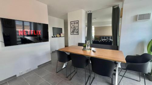 una sala da pranzo con tavolo e sedie in legno di AuraLoft - 3 Zimmer, 2 Bäder, 2 Parkplätze, Balkon & Aufzug a Merseburg