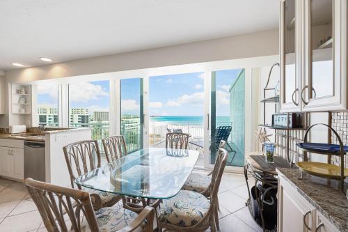 a kitchen with a glass table and chairs and the ocean at Jamaica Royale Beachfront Tower By Beachside Management in Siesta Key