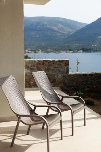 two chairs sitting on a patio with a view of the water at Physis Fokida in Eratini