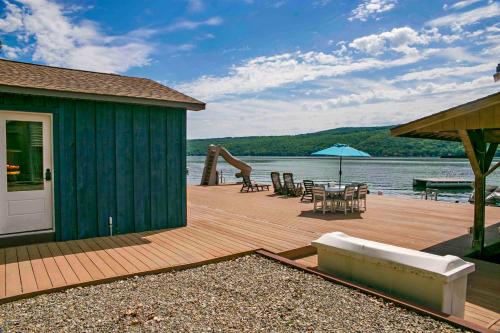 a wooden deck with a house and a table and chairs at The Dockaholic in Hammondsport