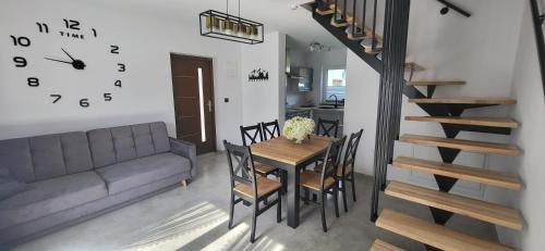 a dining room and kitchen with a table and a clock at Domki i Pokoje u Ilony in Krościenko