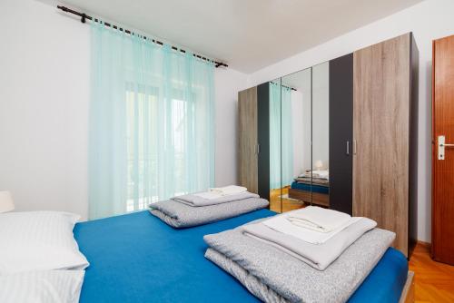 a bedroom with two beds and a mirror at Apartman Antonia in Crikvenica