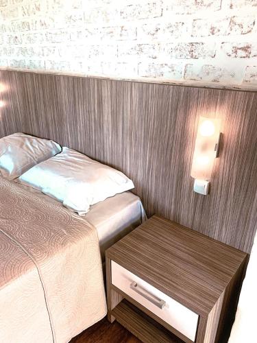 a small bedroom with two beds and a table at Hotel Pousada Água Da Mina in Monte Sião