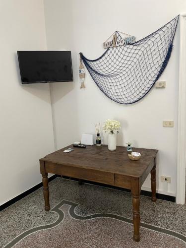 ein Wohnzimmer mit einem Tisch und einer Hängematte in der Unterkunft Il Delfino d'Oro in Savona
