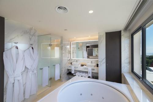 a bathroom with a large tub and a sink at El Embajador, a Royal Hideaway Hotel in Santo Domingo