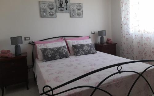 a bedroom with a bed with pink sheets and pillows at Tra Vento e Mare in Lendinuso
