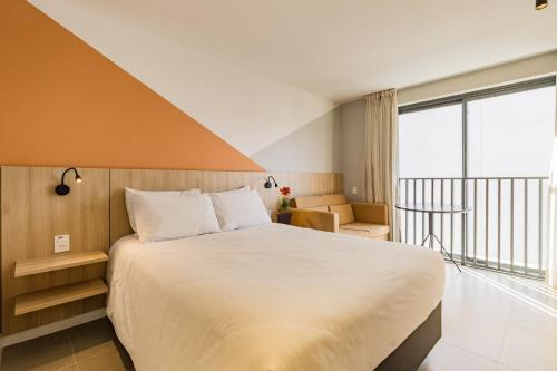 a bedroom with a large bed and a balcony at GO 24 by My Way in Porto Alegre