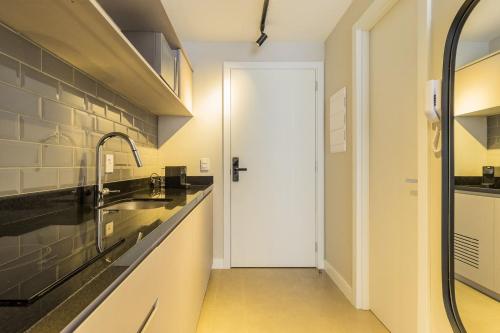 a kitchen with a sink and a white door at GO 24 by My Way in Porto Alegre