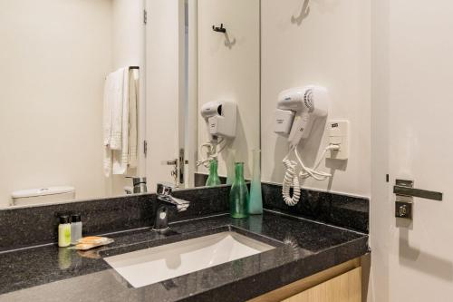 a bathroom with a sink and a hair dryer at GO 24 by My Way in Porto Alegre