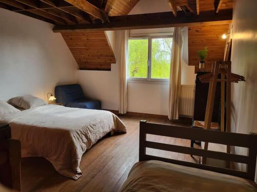 une chambre avec deux lits et une fenêtre et une chaise dans l'établissement Maisonnette jardin - Fontainebleau, Disney, Paris, à Boissise-la-Bertrand