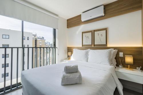a bedroom with a large white bed and a large window at GO 24 by My Way in Porto Alegre