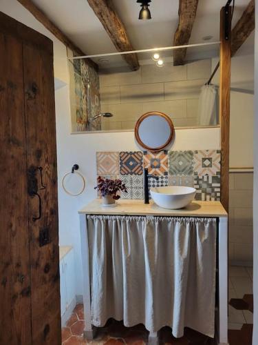 - une table avec un miroir et un bol dans l'établissement Maisonnette jardin - Fontainebleau, Disney, Paris, à Boissise-la-Bertrand