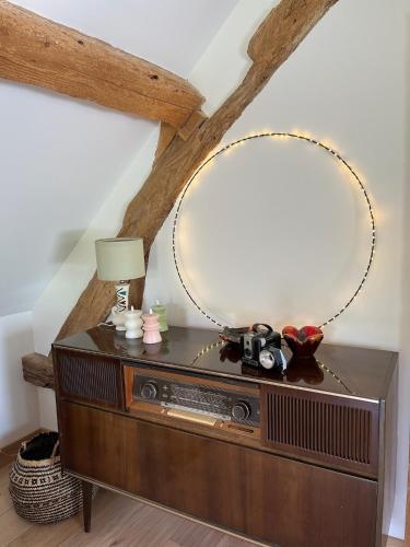 a wooden dresser with a mirror on top of it at Gîtes et Spa en Normandie in Sainte-Marguerite-de-Viette