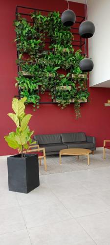 a living wall with a black couch and a plant at Apto Completo con Estudio y CLUB HOUSE in Mosquera