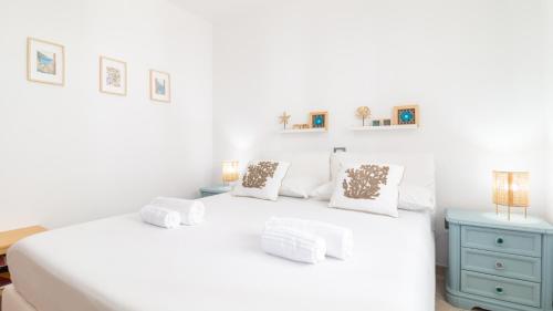 a white bedroom with a white bed and a blue cabinet at Sardinianworld - Casa Dei Bucanieri in Putzu Idu