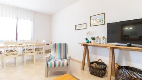 a living room with a television and a dining room at Sardinianworld - Casa Dei Bucanieri in Putzu Idu