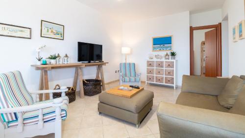 a living room with a couch and chairs and a tv at Sardinianworld - Casa Dei Bucanieri in Putzu Idu