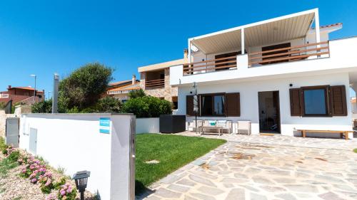 a white house with a patio and a yard at Sardinianworld - Casa Dei Bucanieri in Putzu Idu