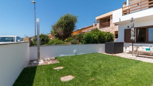 a small backyard with a green yard at Sardinianworld - Casa Dei Bucanieri in Putzu Idu