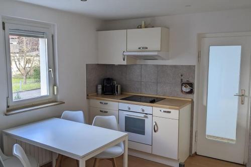 a kitchen with a white table and a table and chairs at Hiloa-Appartment in Wernau in Steinbach