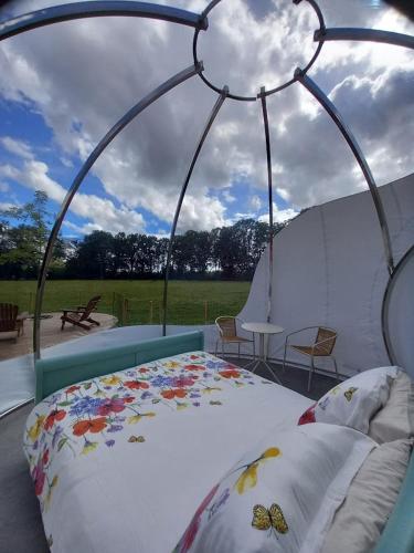 une chambre avec un lit dans une tente dans l'établissement La Bulle des alpagas, à Herry