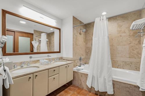 a bathroom with a tub and a sink and a shower at Las Casitas Village at El Conquistador in Fajardo