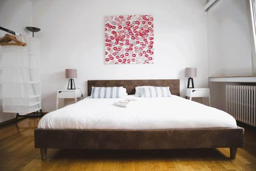 a bedroom with a large white bed with two lamps at Charming Penthouse in the City Center in Luxembourg