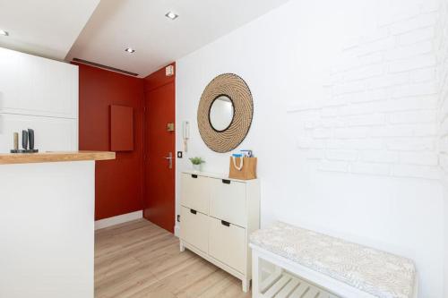 une cuisine avec des murs rouges et un meuble blanc dans l'établissement Charmant studio climatisé, à Antibes