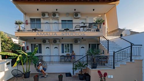 a woman sits on a skateboard in front of a building at Amalia in Stavros