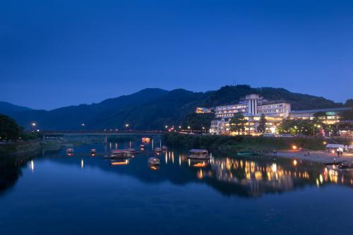 a city at night with boats in the water at Iwakuni Kokusai Kanko Hotel in Iwakuni
