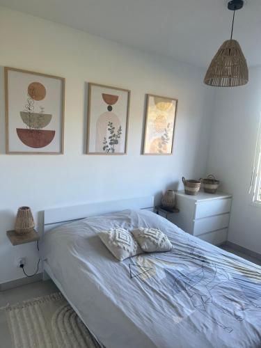 - une chambre avec un lit et trois photos sur le mur dans l'établissement Appartement T3 avec belle vue, à Fréjus