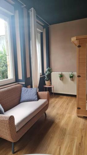 a living room with a couch and two windows at Balnéo in Vesoul