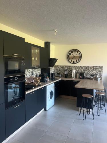 une cuisine avec des armoires noires et une table. dans l'établissement Appartement T3 avec belle vue, à Fréjus