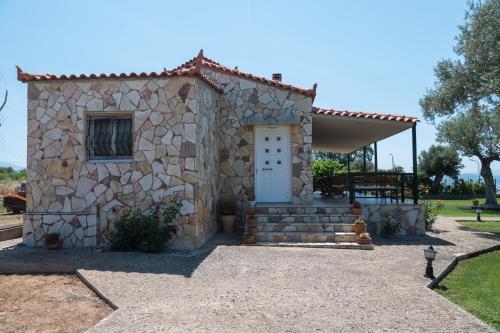 a small stone house with a white door at Luxury Beach Villa in Skála