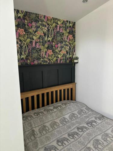 a bedroom with a bed with a floral wallpaper at Private apartment with en-suite in Bournemouth