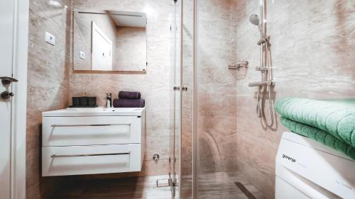 a bathroom with a sink and a shower at Yourhome beach first line in Dobra Voda