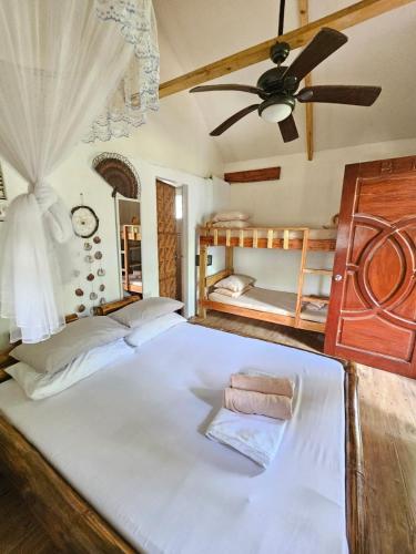 a bedroom with two beds and a ceiling fan at Big BamBoo Beach Resort Sipalay in Sipalay