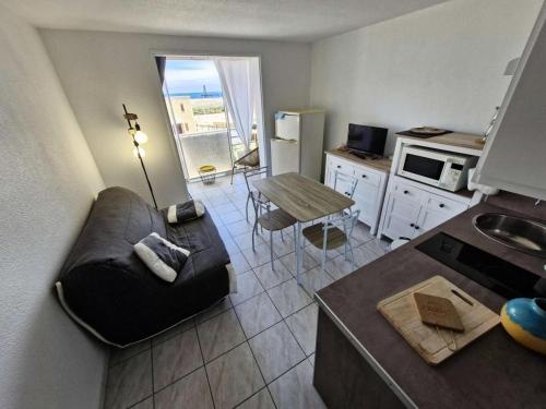 une cuisine et un salon avec un canapé et une table dans l'établissement Résidence Belle Plage - 2 Pièces pour 4 Personnes 281, à Leucate