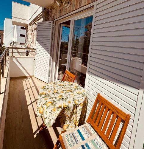 a table and chairs sitting on a porch with a table and chairs at Orfeu apartments Ksamil in Ksamil