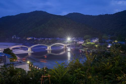 a view of a bridge over a river at night at Iwakuni Kokusai Kanko Hotel in Iwakuni