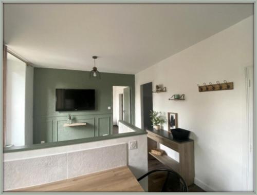 un salon avec une télévision à écran plat au mur dans l'établissement T2 tout confort hyper centre, à Mont-Dore