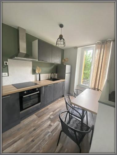 - une cuisine avec une table, une table et des chaises dans l'établissement T2 tout confort hyper centre, à Mont-Dore