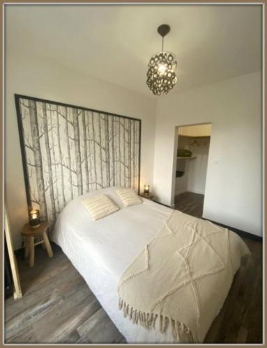 une chambre avec un lit et un lustre dans l'établissement T2 tout confort hyper centre, à Mont-Dore