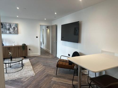 a living room with a table and a tv on a wall at Museum View Apartments City Centre 1 Bedroom in Cardiff